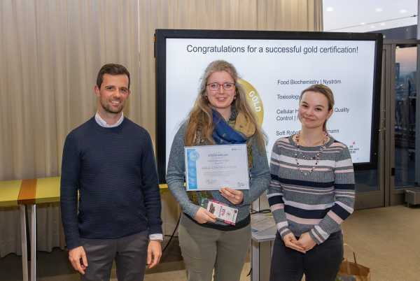 Janka Zsok accepts the gold certificate for the Weis lab.